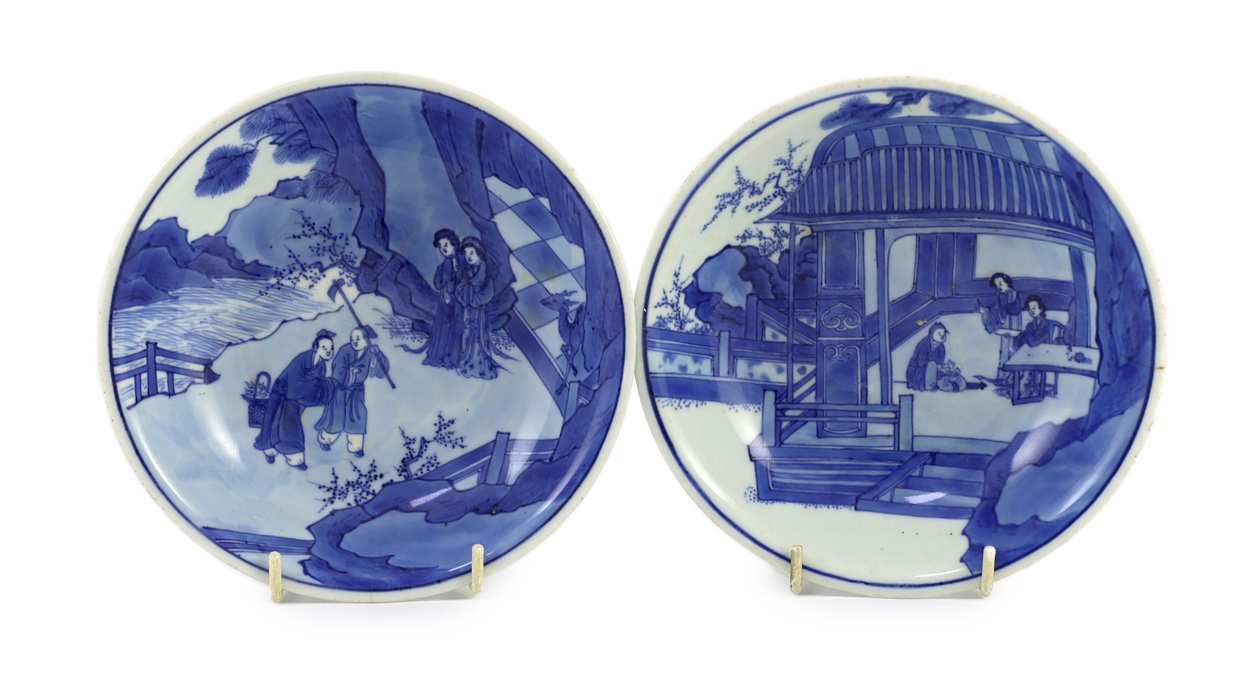 NB BOTH WITH HAIRLINE CRACKS A pair of Chinese blue and white small dishes, Kangxi six character marks and of the period (1662-1722), 15.7cm and 15.8cm diameter, foot later pierced, hairline cracks
